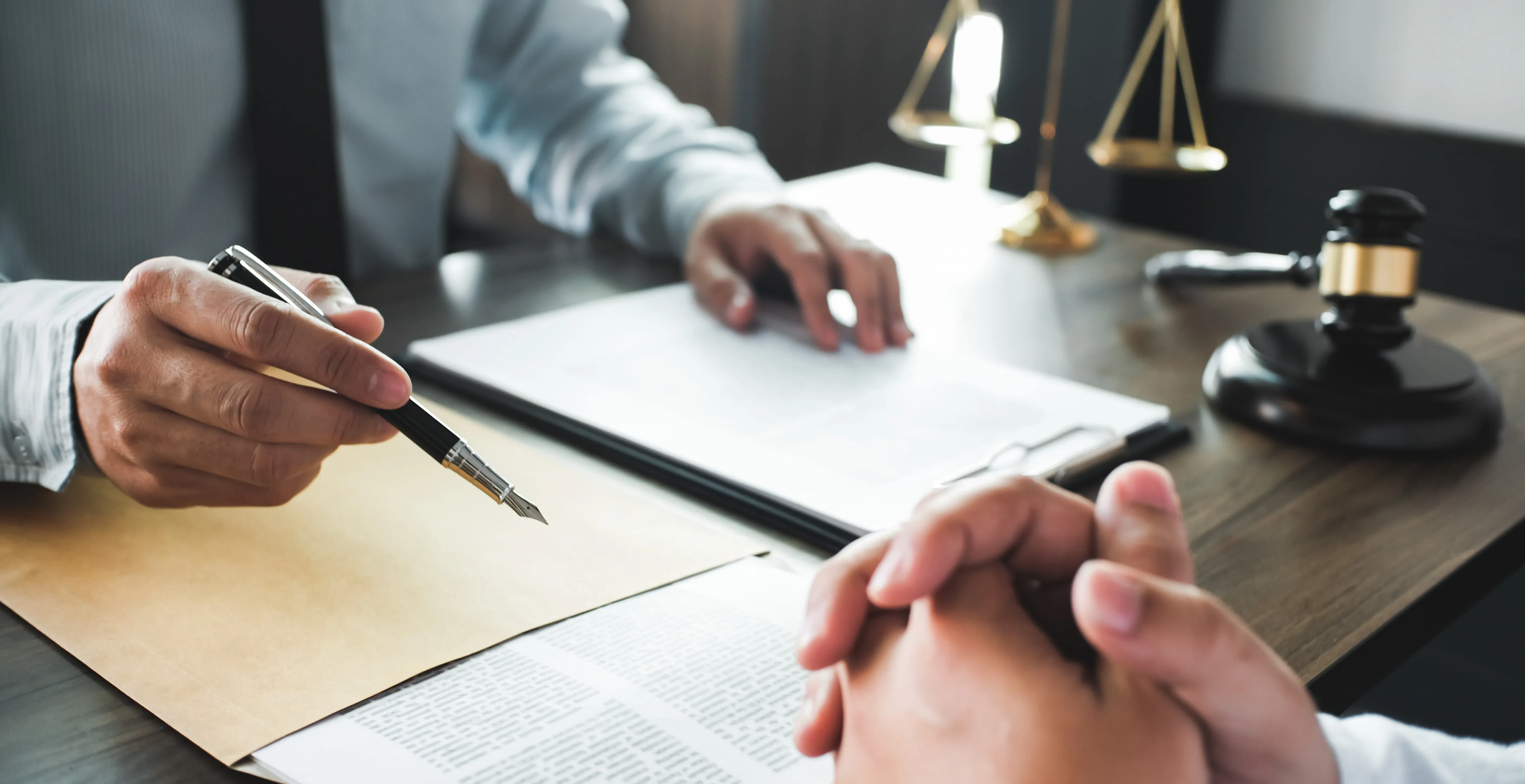 Beratungsgespräch mit Dokumenten, Stift und Richterhammer