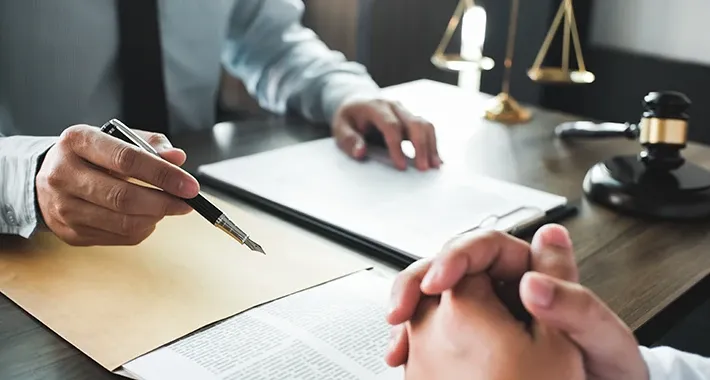 Beratungsgespräch mit Dokumenten, Stift und Richterhammer