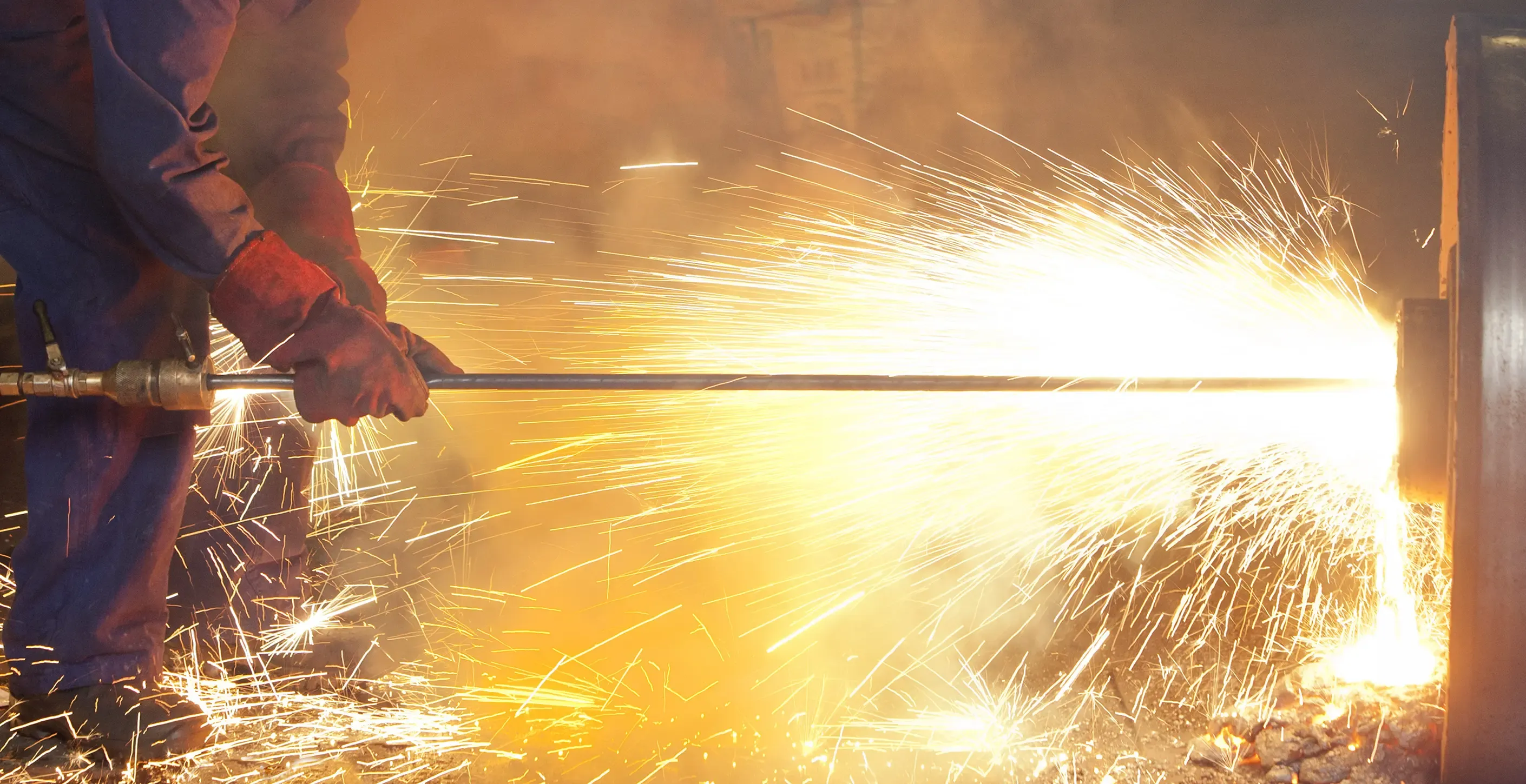 Metallbearbeitung mit starkem Funkenflug in einer industriellen Produktionsumgebung