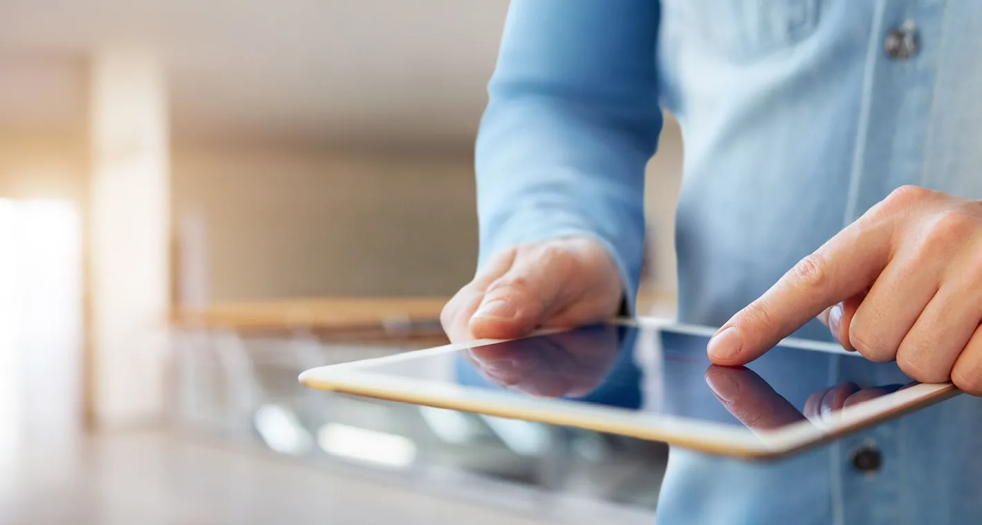 Person bedient ein Tablet mit dem Finger