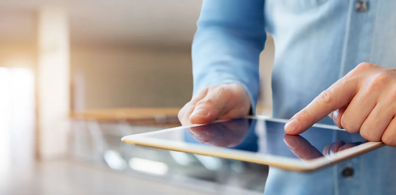 Person bedient ein Tablet mit dem Finger