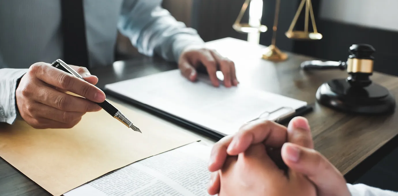 Beratungsgespräch mit Dokumenten, Stift und Richterhammer