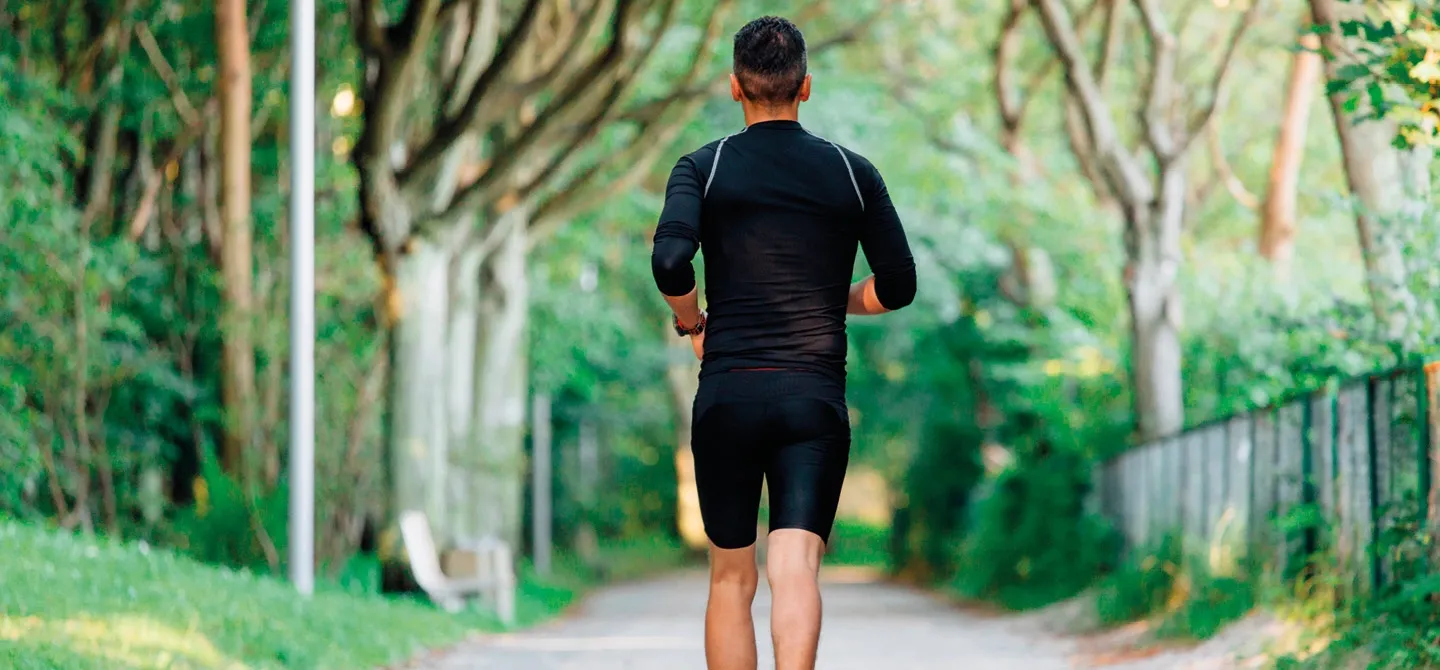 Person joggt auf einem Weg im Grünen