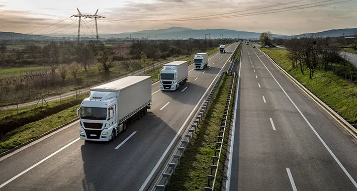 Luftaufnahme einer Autobahn mit mehreren LKW im Güterverkehr